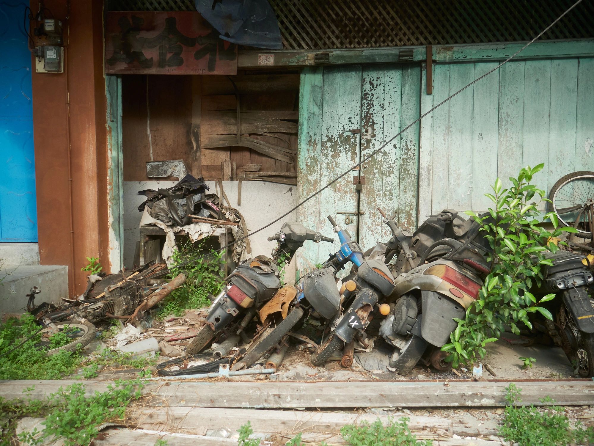 Collection of motorcycles outside an old wooden shop